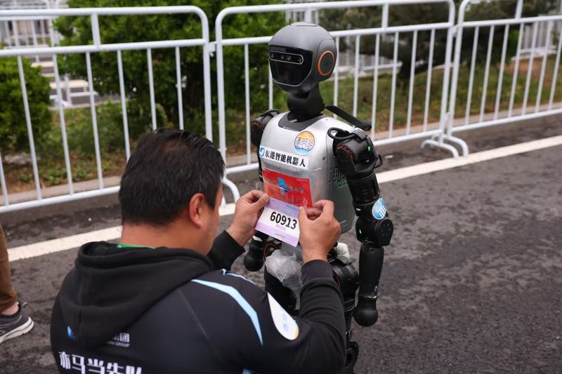 工作人员给参赛人形机器人贴标签。新京报记者 李木易 摄