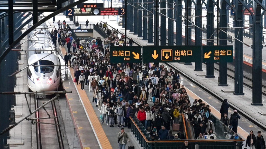 5月1日，旅客从哈尔滨火车站下车出站。新华社 图